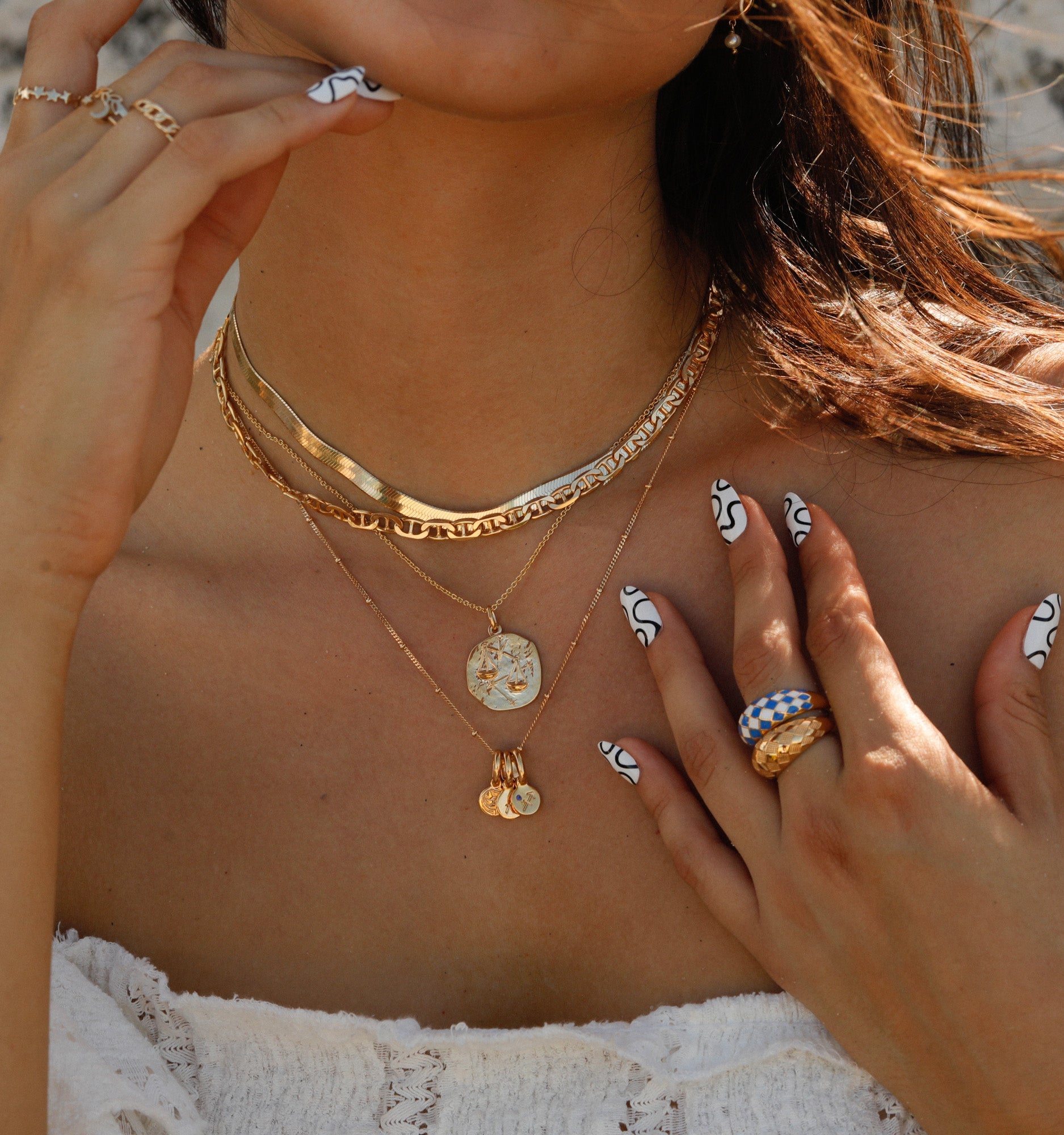 model wearing a stack of four layered necklaces